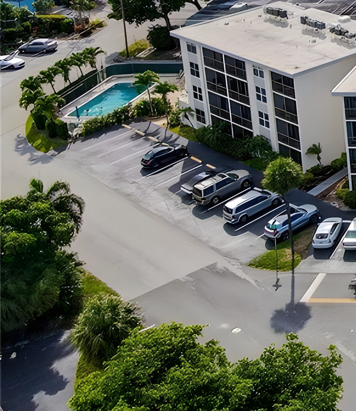 The pool between the parking and the street, with the building behind it.
